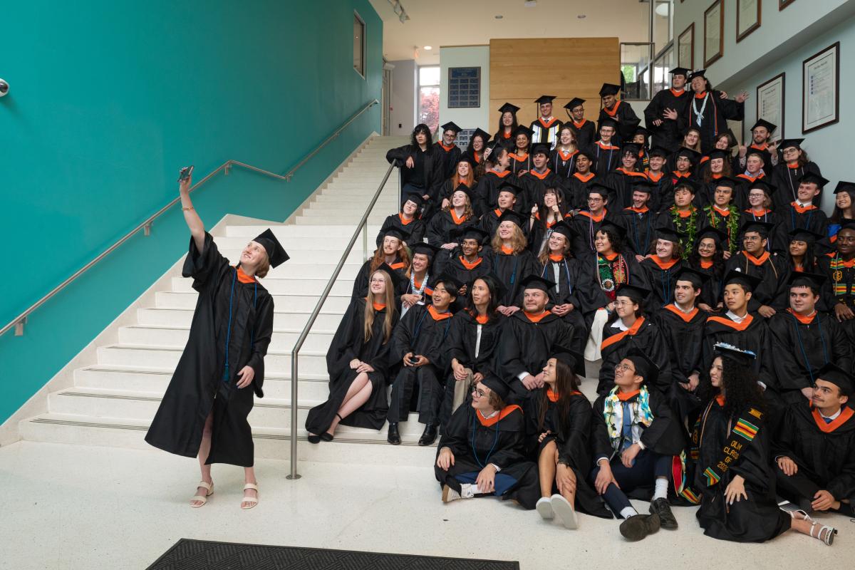 Maya McKone-Sweet ’26 takes a selfie with her fellow graduates as they prepare to take the group photo for Olin College of Engineering's Class of 2026