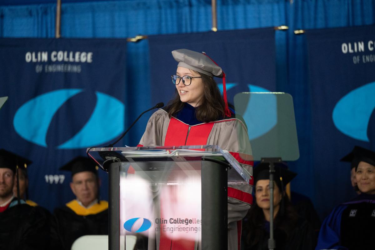 Faculty Speaker Victoria Preston ’16, Assistant Professor of Engineering and Olin Alumn, speaking from the podium at Olin's Commencement Ceremony on May 15, 2026