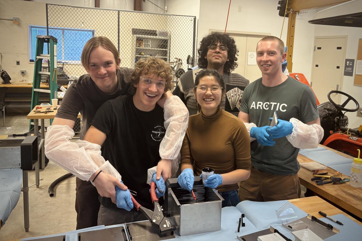 A group photo of OCTAL team members posing with their drone's battery packs