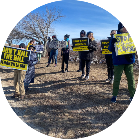 Students holding protest signs advocating against mining in Cedarville, MA