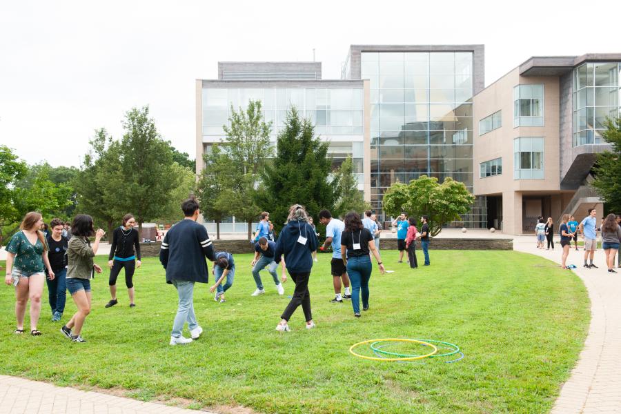 a group of students congregate outside in the center of campus