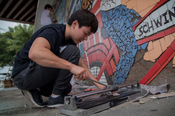 A student works on a mural