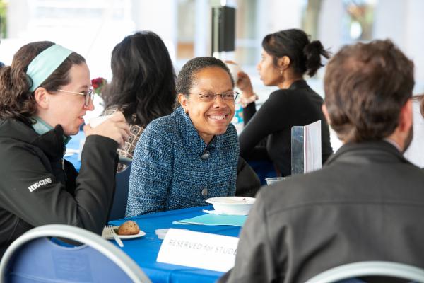 President Barabino sitting at a table talking to alumni