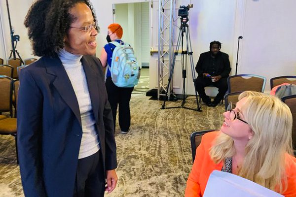 Two women face each one another as they converse