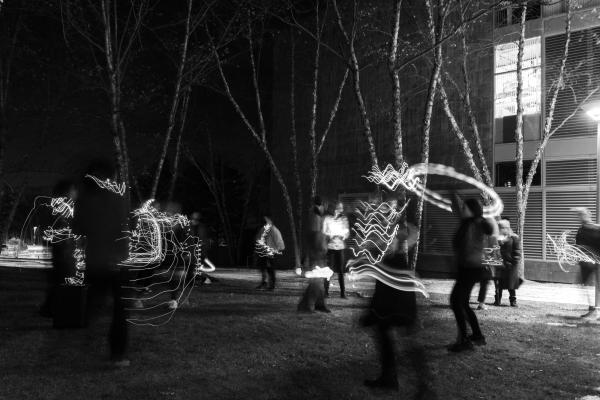 A black and white photo of students at Olin dancing with glow in the dark materials and clothes.
