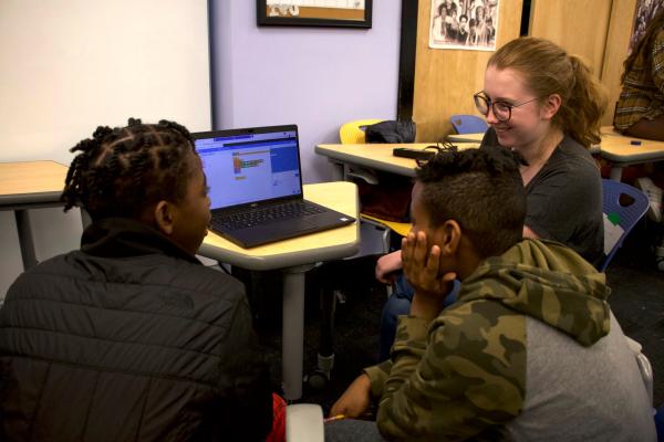 Esme Abbot ‘24 sits with students during the Human & Scratch Video Game Programming Workshop