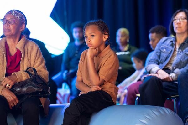 kid in the audience listening to performances