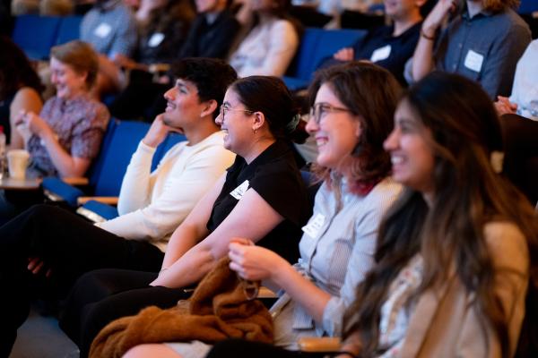 Audience members smiling during Summit presentation