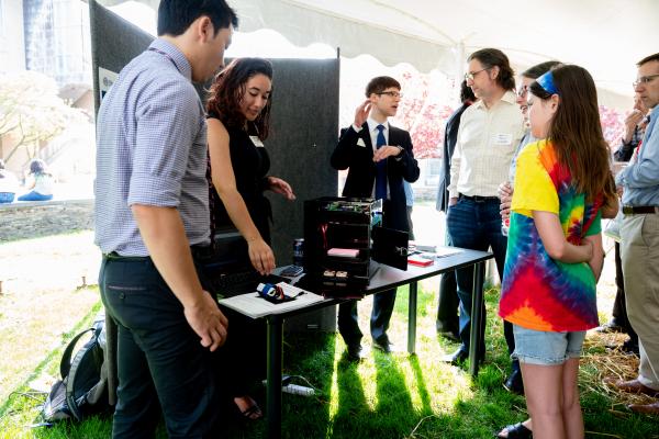 SCOPE Students discussing their Flybox with young girl and family