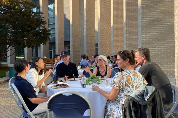 Participants and faculty sharing a meal outdoors