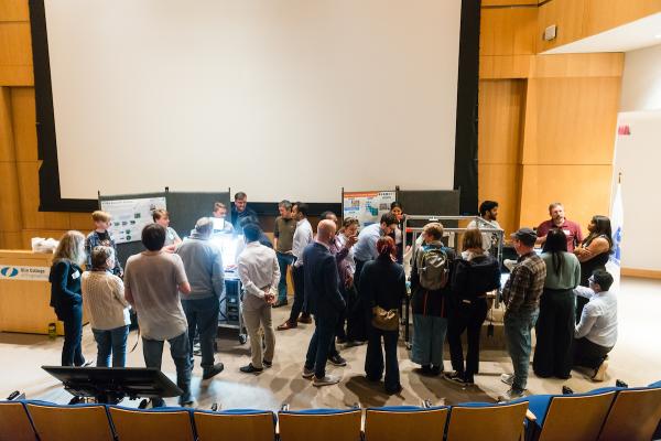 Distance view of students and attendees gathered around poster presentation during SCOPE Summit 