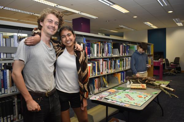 Two students stand in front of their final project. 