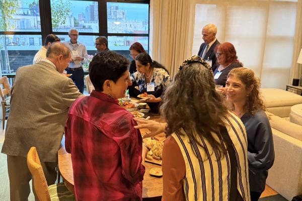 People gather around refreshments during the Olin on the Road trip to New York City.