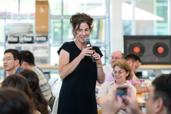 Gillian Epstein with a microphone speaking to Summer Studio attendees. 