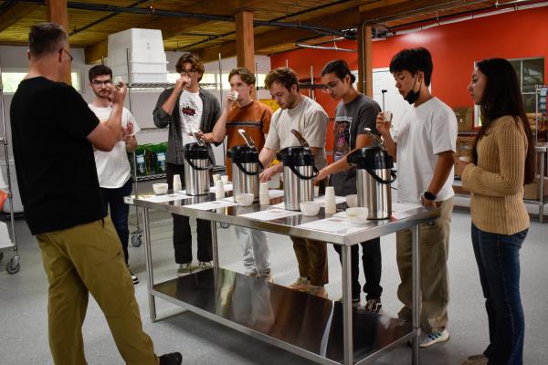 Jim Varney, Wavelength co-owner, in front of a table speaking to students. 