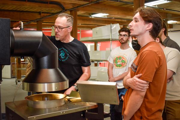 Jim Varney, Wavelength co-owner, showing students the air roasting process.