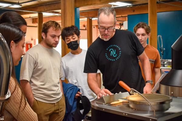 Jim Varney, Wavelength co-owner, showing students the air roasting process.