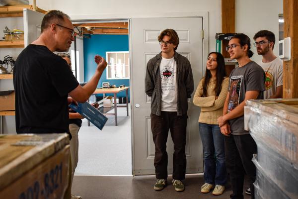 Jim Varney, Wavelength co-owner, speaking with students in a storage room. 
