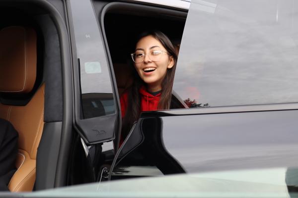 An Olin OEM member smiles while sitting in a car. 