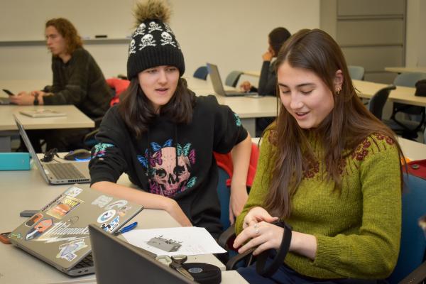 Two Olin OAT project team members sit together and work on a project.