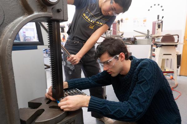 Two Olin OCTAL project team members work in the machine shop.