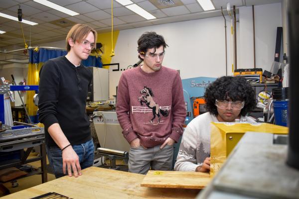 Three Olin OCTAL project team members work together in the wood shop.