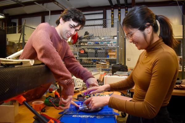 Two Olin OCTAL project team members work together at a workbench.