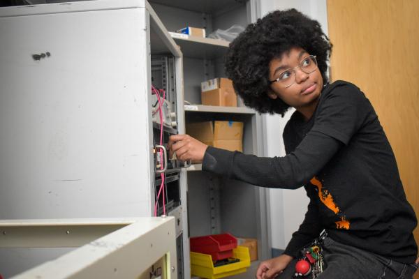 An Olin OPEL project team member crouches down to adjust equipment.