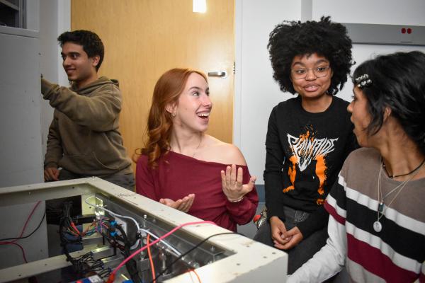 Four Olin OPEL project team members observe the thruster.  