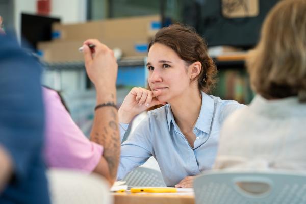 An Olin Summer Studio 2025 participant smiles while talking with a team member.