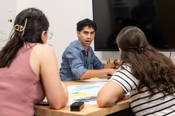 Olin Summer Studio participants engage in program work while sitting at a table in a classroom.