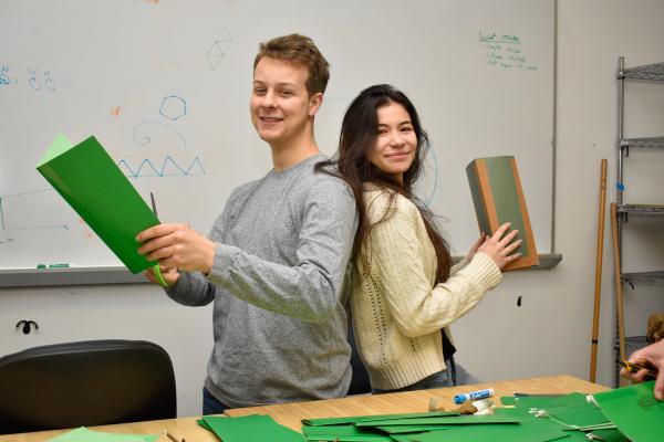 Two MechProto students pose with pieces of their 