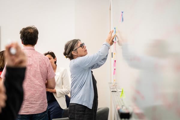 A Makerspace Institute participant stands at a white board. 