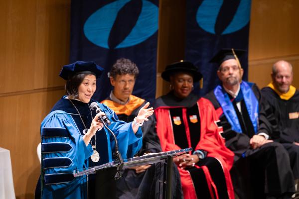 President Lee standing at the podium during her inauguration in front of distinguished guests and speakers